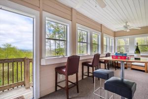 une salle à manger avec une table, des chaises et des fenêtres dans l'établissement 10 Min To Dt, 15 Min To Biltmore, Fire Pit, View, à Asheville