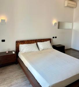 a bedroom with a large bed with a brown headboard at 2 bed Flat near Metro of Sesto San Giovanni in Sesto San Giovanni +20 photos