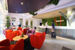 a hotel lobby with orange chairs and a counter at Hotelday Plus Tamsui in Tamsui
