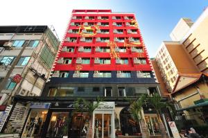 un edificio alto rojo con un reloj en él en Elizabeth Hotel, en Taichung