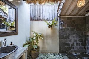a bathroom with a sink and a shower with plants at Villa La Luna 2BR Joglo Style with Pool by Damaresa in Dalung +51 photos
