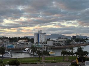 a city with a river and buildings and palm trees at Marina View Apartment in Townsville