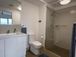 a bathroom with a toilet and a glass shower at Marina View Apartment in Townsville