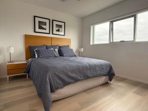 a bedroom with a large bed and two windows at Marina View Apartment in Townsville