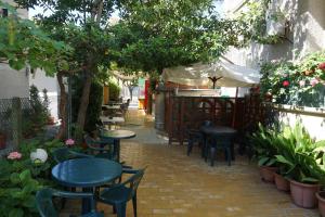 a patio with tables and chairs and an umbrella at Guest House Lambovi in Nesebar