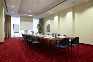a conference room with a long table and chairs at IntercityHotel Schwerin in Schwerin
