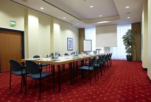 a conference room with a long table and chairs at IntercityHotel Schwerin in Schwerin