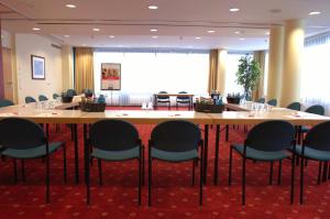 a conference room with a large table and chairs at IntercityHotel Schwerin in Schwerin
