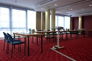 a conference room with tables and chairs and windows at IntercityHotel Schwerin in Schwerin