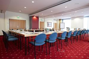 a large conference room with a long table and chairs at IntercityHotel Schwerin in Schwerin
