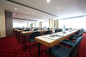 a row of tables and chairs in a room at IntercityHotel Schwerin in Schwerin