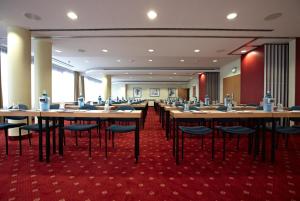 a conference room with wooden tables and chairs at IntercityHotel Schwerin in Schwerin