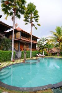 a large swimming pool in front of a house at Villa Karma Loka in Sidemen