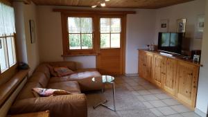 ein Wohnzimmer mit einem Sofa und einem TV in der Unterkunft Ferienwohnung Gadenstatt in Davos