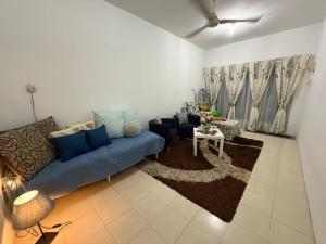 a living room with a blue couch and a table at Rumah Inap Wancu formuslim in Gambang