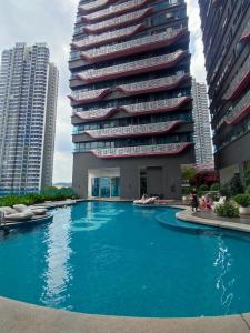 a building with a swimming pool in front of a building at Comfy Room in High Floor! in Kuala Lumpur