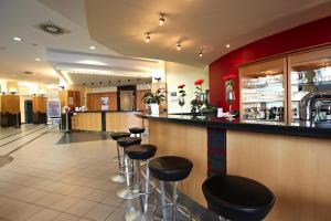 a bar in a restaurant with stools at IntercityHotel Schwerin in Schwerin