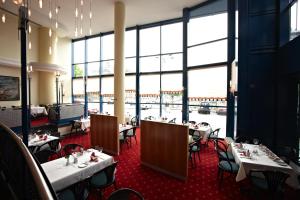 a restaurant with tables and chairs and large windows at IntercityHotel Schwerin in Schwerin