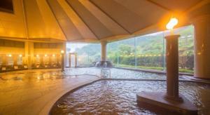 una piscina d'acqua in un edificio con una grande finestra di Yufuin Onsen Yufuin Nanairo no Kaze a Yufu Altre 37 foto