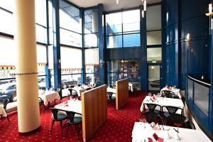 a restaurant with tables and chairs and large windows at IntercityHotel Schwerin in Schwerin