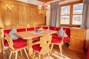 uma sala de jantar com uma mesa e cadeiras vermelhas em Ferienwohnungen Liegmann em Oberstdorf