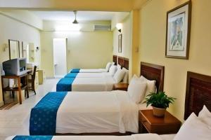 a hotel room with two beds and a television at Seapark Condotel Hotel in Tanjong Aru