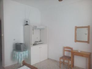 kuchnia z lodówką, krzesłem i lustrem w obiekcie Karagiozos Studios & Apartments w mieście Skopelos +37 zdjęć