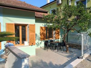 a house with a table and chairs next to a tree at Casa del Limone in San Bartolomeo al Mare