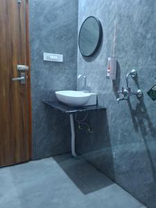 Hanumant Resort في دهرادون: حمام مع حوض ومرآة