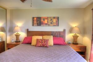 a bedroom with a large bed with two lamps at Menehune Shores 223 condo in Kihei