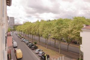 una strada con una fila di alberi sul lato della strada di Suite Balneo Hammam Noire et Or a Saint-Étienne