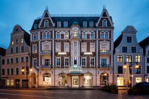 a large building in the city at night at Pentahotel Rostock in Rostock