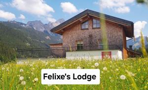 a house in a field of flowers with the words fables lodge at Braito's Seaside Lodges und Suites, Ferienhäuser und Ferienwohnungen in Haldensee