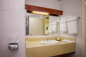 a bathroom with a sink and a mirror at Sirikwa Hotel in Eldoret