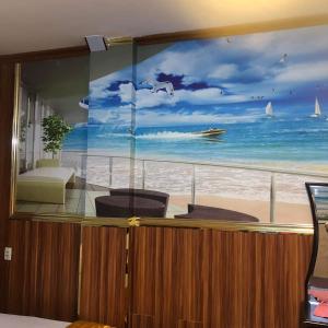 a mural of a beach with a boat in the ocean at Khách sạn PARIS 3 đường 38 phường Tân Tạo Quận Bình Tân in Ho Chi Minh City