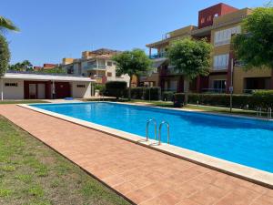 a large blue swimming pool in front of a building at Apartamento en Hacienda del Alamo enfrente de la Piscina! in Fuente-Álamo de Murcia