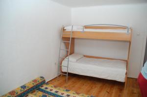 a room with two bunk beds and a rug at Stanjel Carst House 13 Andreja in Štanjel