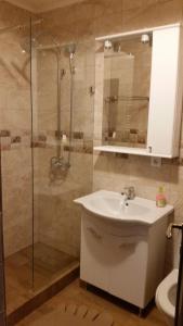 a bathroom with a sink and a glass shower at Apartament la mare Mamaia Nord in Mamaia Nord