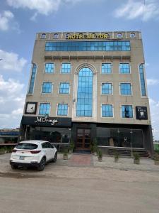 a white car parked in front of a building at Hotel Milton islamabad in Islamabad