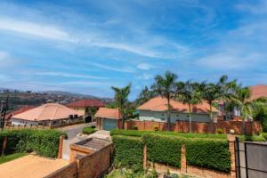 a house with a fence and palm trees at kigali Pillar House inn in Kigali