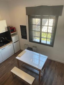 a small kitchen with a table and a window at Studio climatisé au centre du village in Saint-Michel-lʼObservatoire