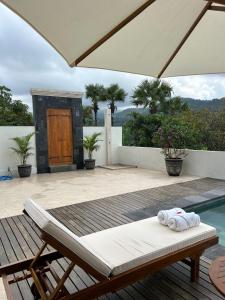 a patio with a pool and a table and an umbrella at Umah tumbu villa, private villa in Seraya +16 photos