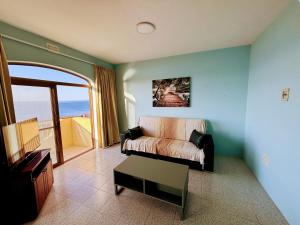 a living room with a couch and a view of the ocean at SeaView Sunset Gozo in Marsalforn