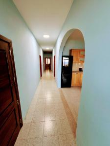 a hallway leading to a kitchen with a black refrigerator at SeaView Sunset Gozo in Marsalforn