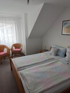 un dormitorio con dos camas y dos sillas en Gästehaus Keller, en Meersburg