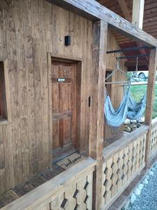 a wooden cabin with a hammock in it at Echo Magura in Măgura
