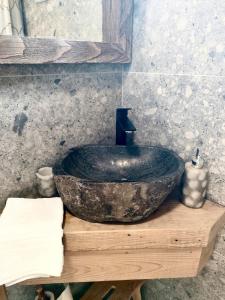 a bathroom with a large stone sink on a wooden table at Echo Magura in Măgura +22 photos