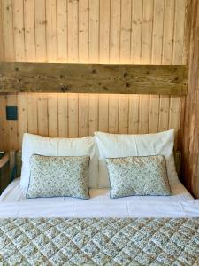 a white bed with two pillows and a wooden wall at Echo Magura in Măgura