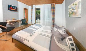 Un dormitorio con dos camas y una silla y una ventana. en Pension und Weingut Moselblick, en Brauneberg