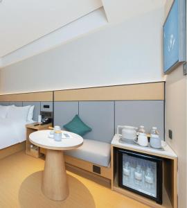 una pequeña habitación con una mesa y una cama en JI Hotel Beijing Capital Economic and Trade Jijiamiao Subway Station, en Beijing